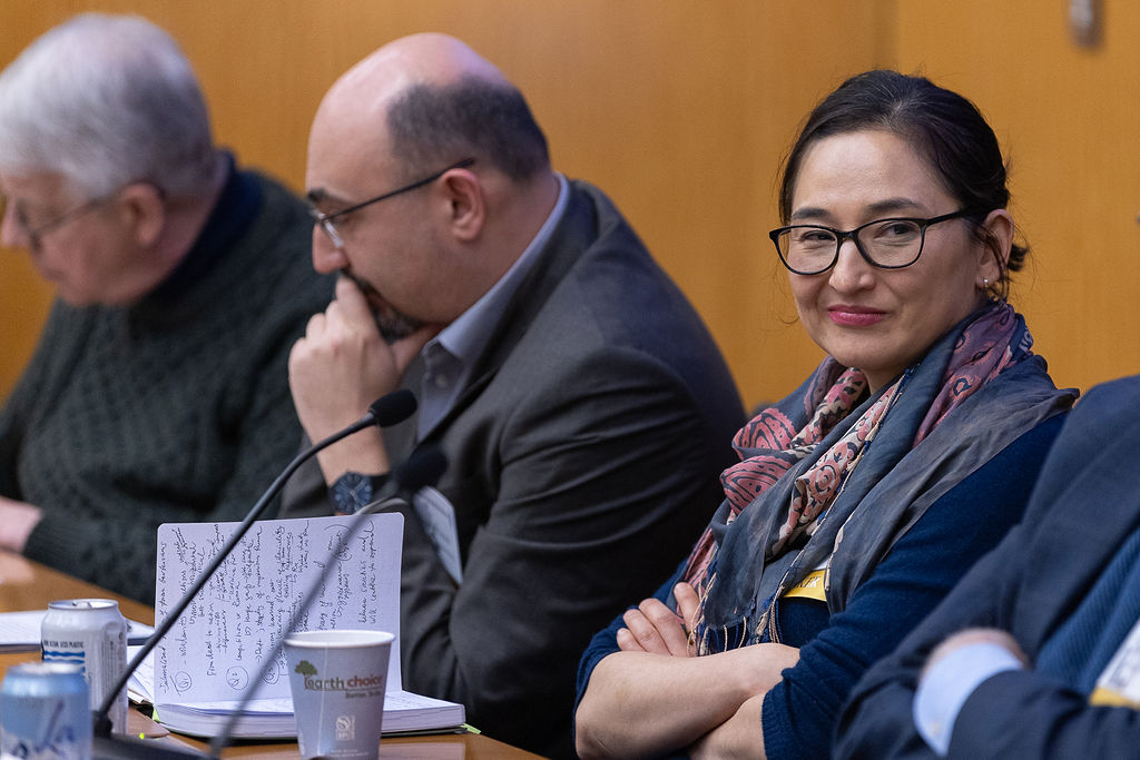 Erica Marat smiles while listening to a fellow speaker at the TCUP 2024 conference.