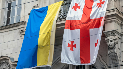 Ukrainian and Georgian flags hung side by side on a Georgian street.