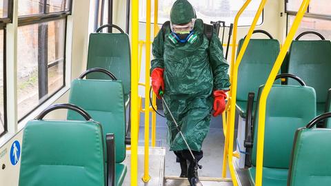 Suited man disinfects bus