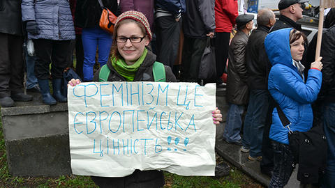 Emily Channell-Justice a protest with sign reading Feminism is a European Value