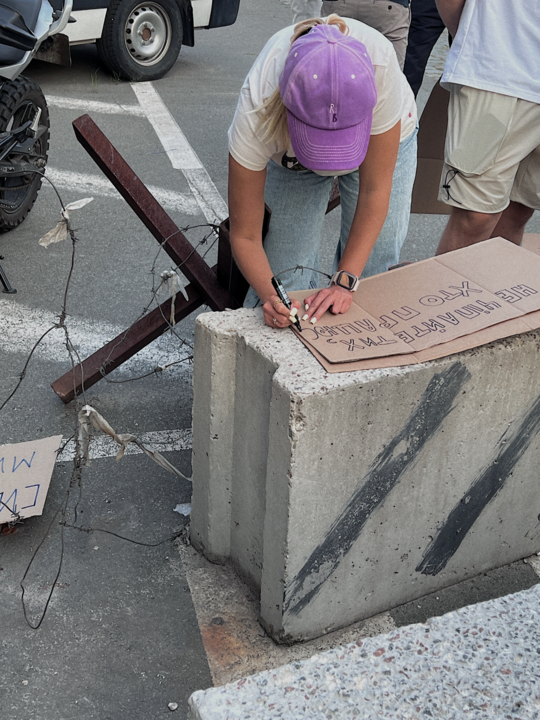 A protester creates a cardboard sign in Kyiv