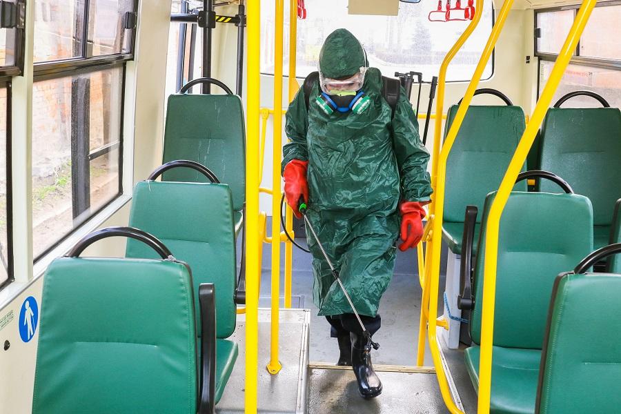 Suited man disinfects bus