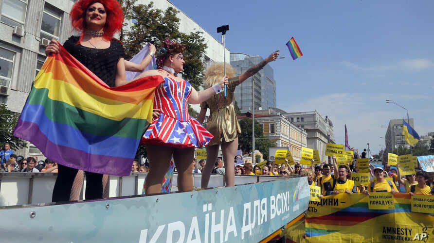 Gay and lesbian rights activists demonstrate as participants of the annual Gay Pride parade wave from a float in Kyiv, Ukraine, June 18, 2017 (AP via VOA)