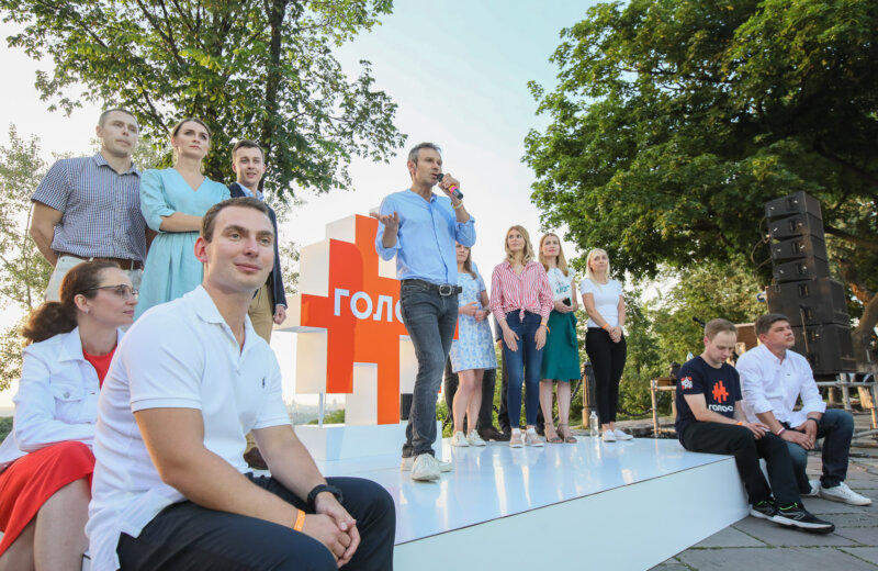Rock star and leader of the Voice (Holos) political party Svyatoslav Vakarchuk speaks with journalists while surrounded by some of his party’s top candidates for parliament on June 8, 2019 in Kyiv. Photo by Volodymyr Petrov. Via Kyiv Post.