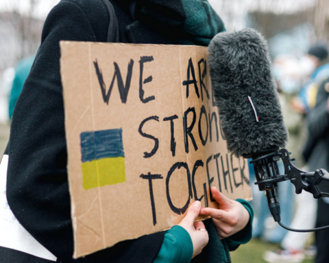 Woman holding a protest sign "We are stronger together."