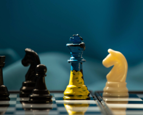 A chessboard with yellow and blue chess pieces