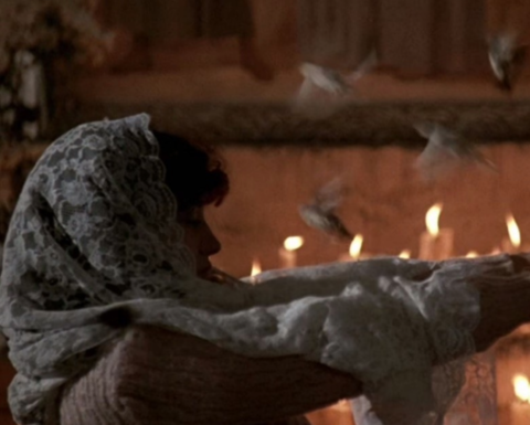 Woman in a church with a candle.