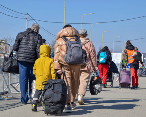 Refugees with bags walking away