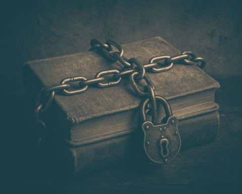 Old books bound by chain with lock