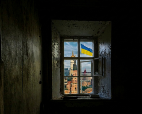 The city of Kharkiv with a Ukrainian flag as seen through a window