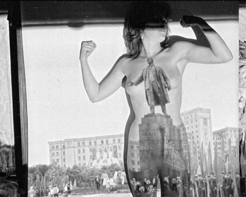 A nude woman photographed in front of a projector screen